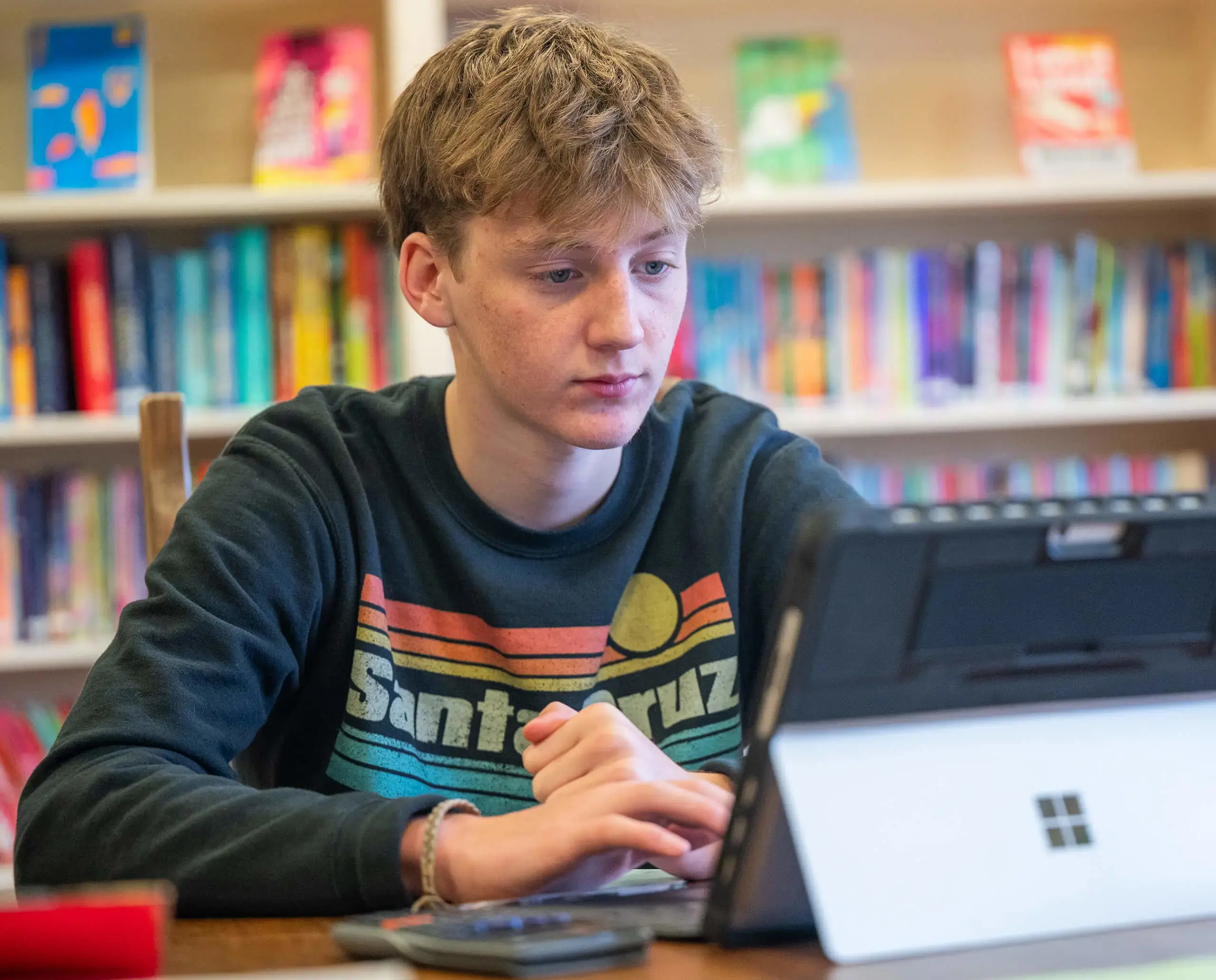 Active revision student working on a laptop in the library