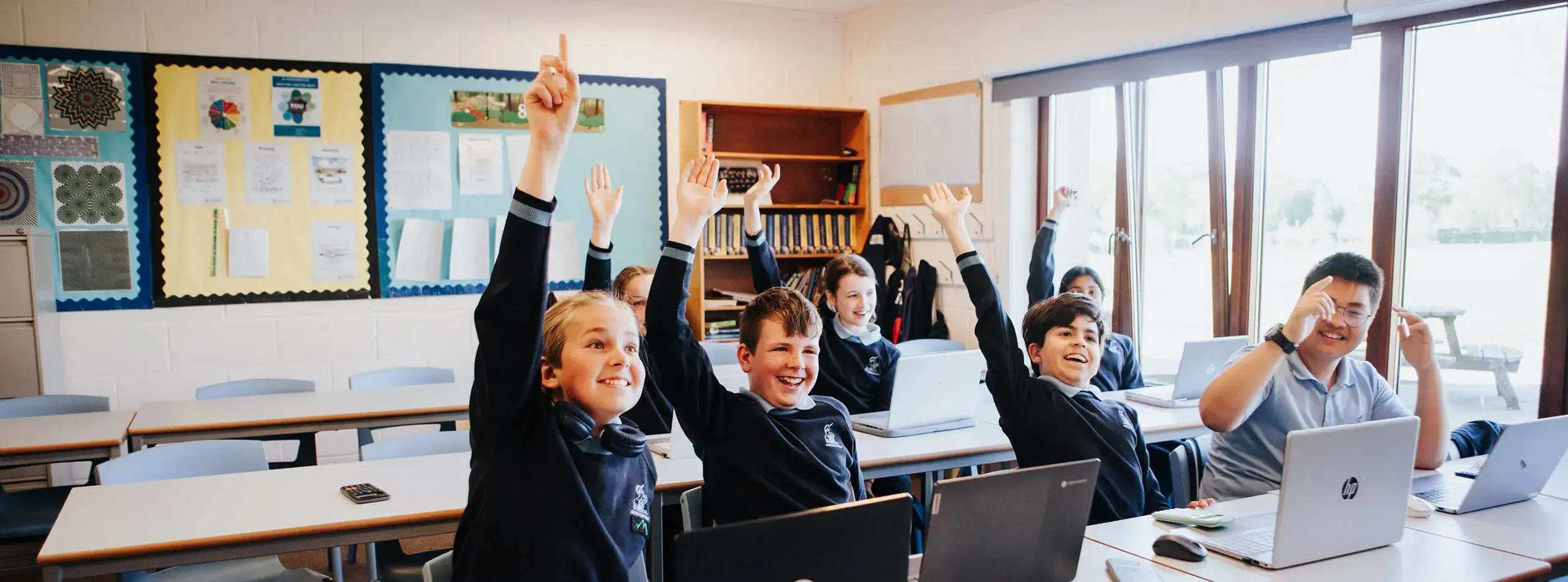 Students with their hands in the air to ask questions