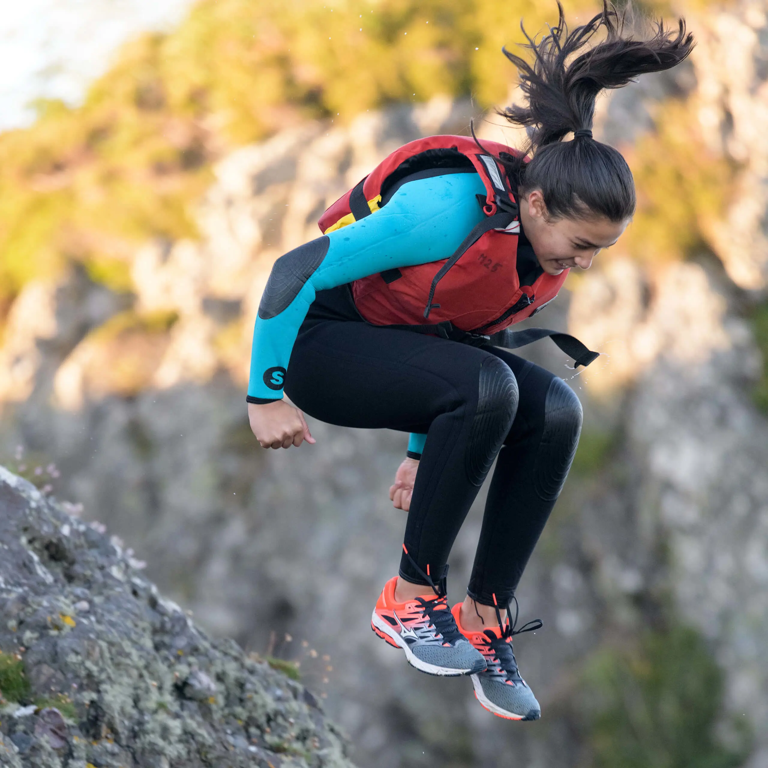 Girl jumping off rocks