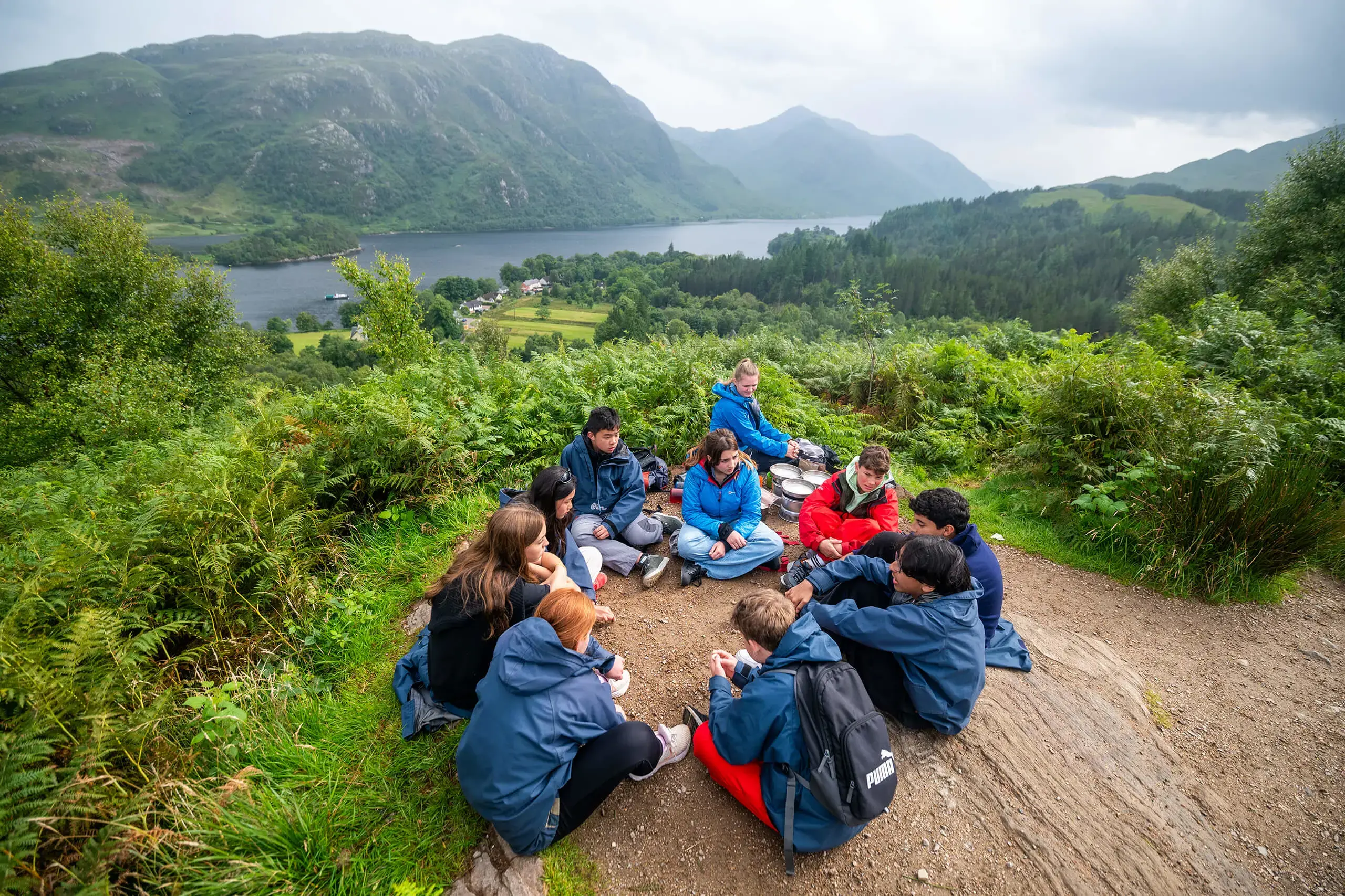 Gordonstoun Summer School Students sitting in a circle on the top of a hill in Scotland.