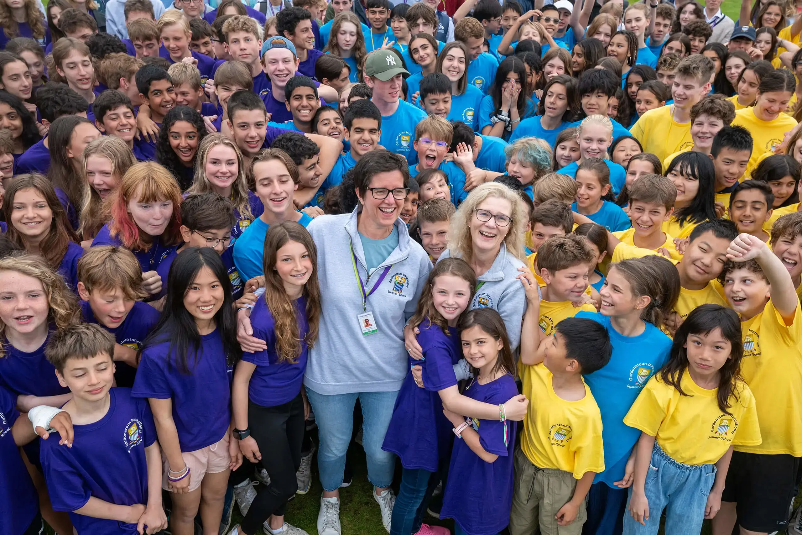 Gordonstoun Summer Camp staff surrounded by lots of children in a giant group photograph. 