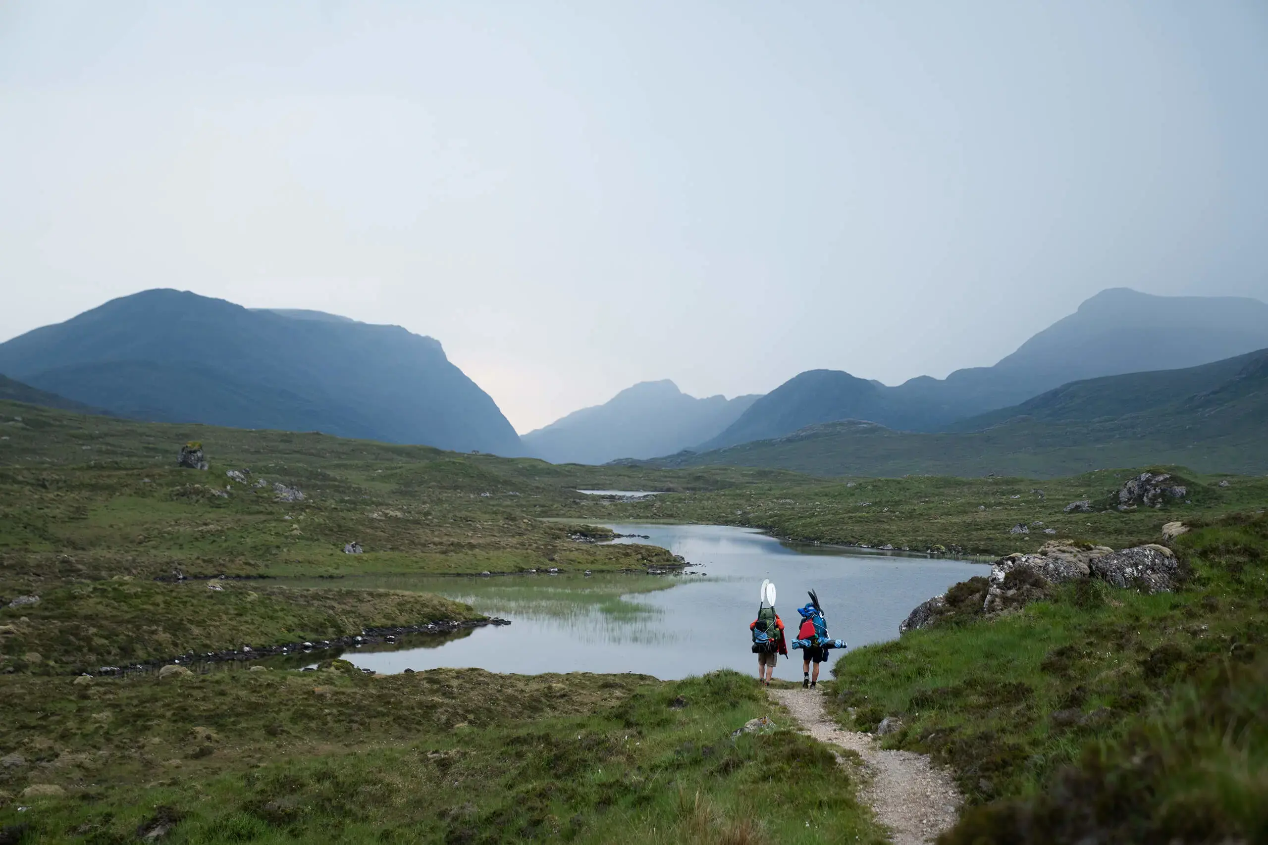 Two Gordonstoun pupils standing by a lake while on a hike