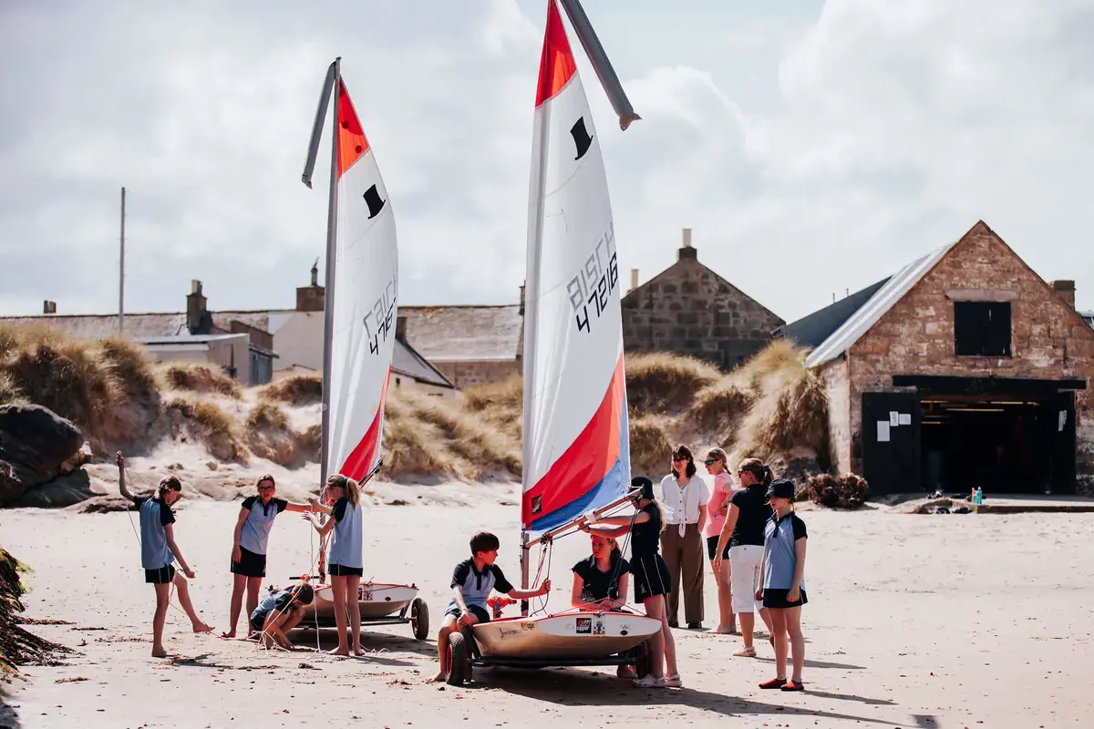 Gordonstoun Prep pupils with boats on beach in the sunshine