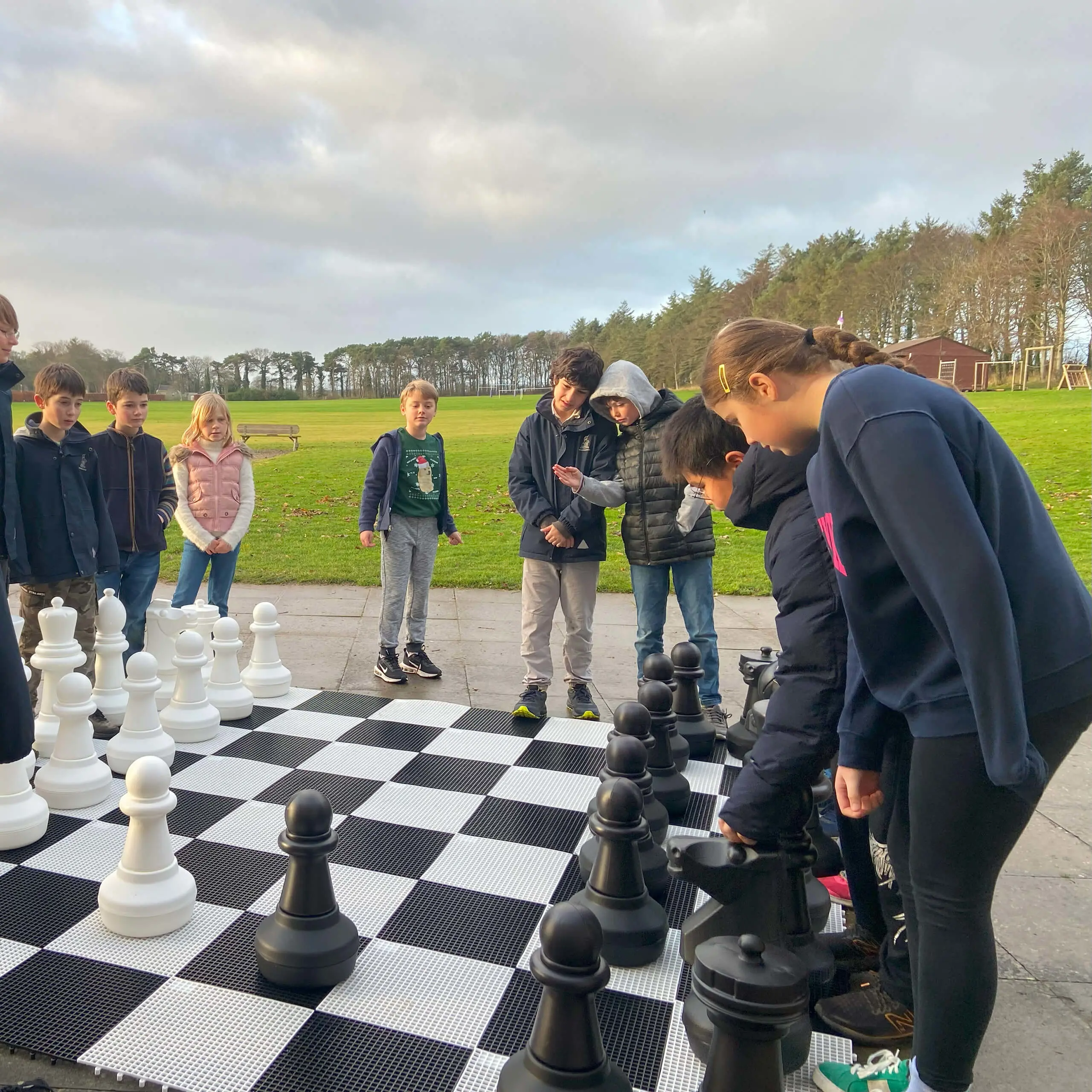 Prep pupils playing a game of giant chess outside