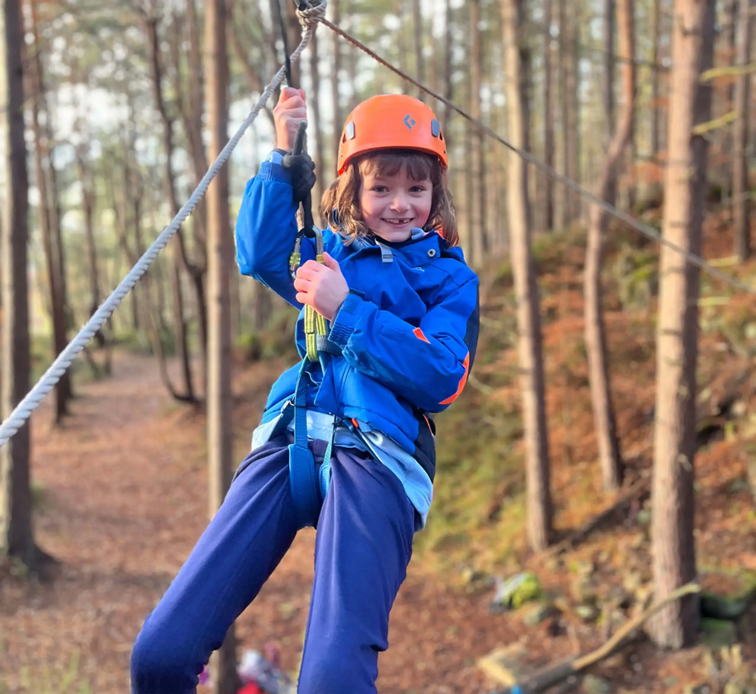 Gordonstoun Prep student on a zipline in the woods in Scotland.