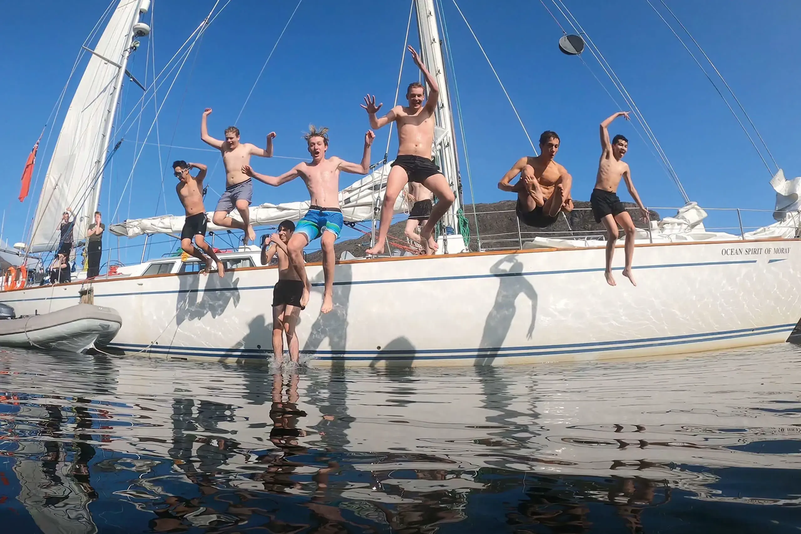 Gordonstoun students jumping off Ocean Spirit of Moray, the School’s own sail training vessel.