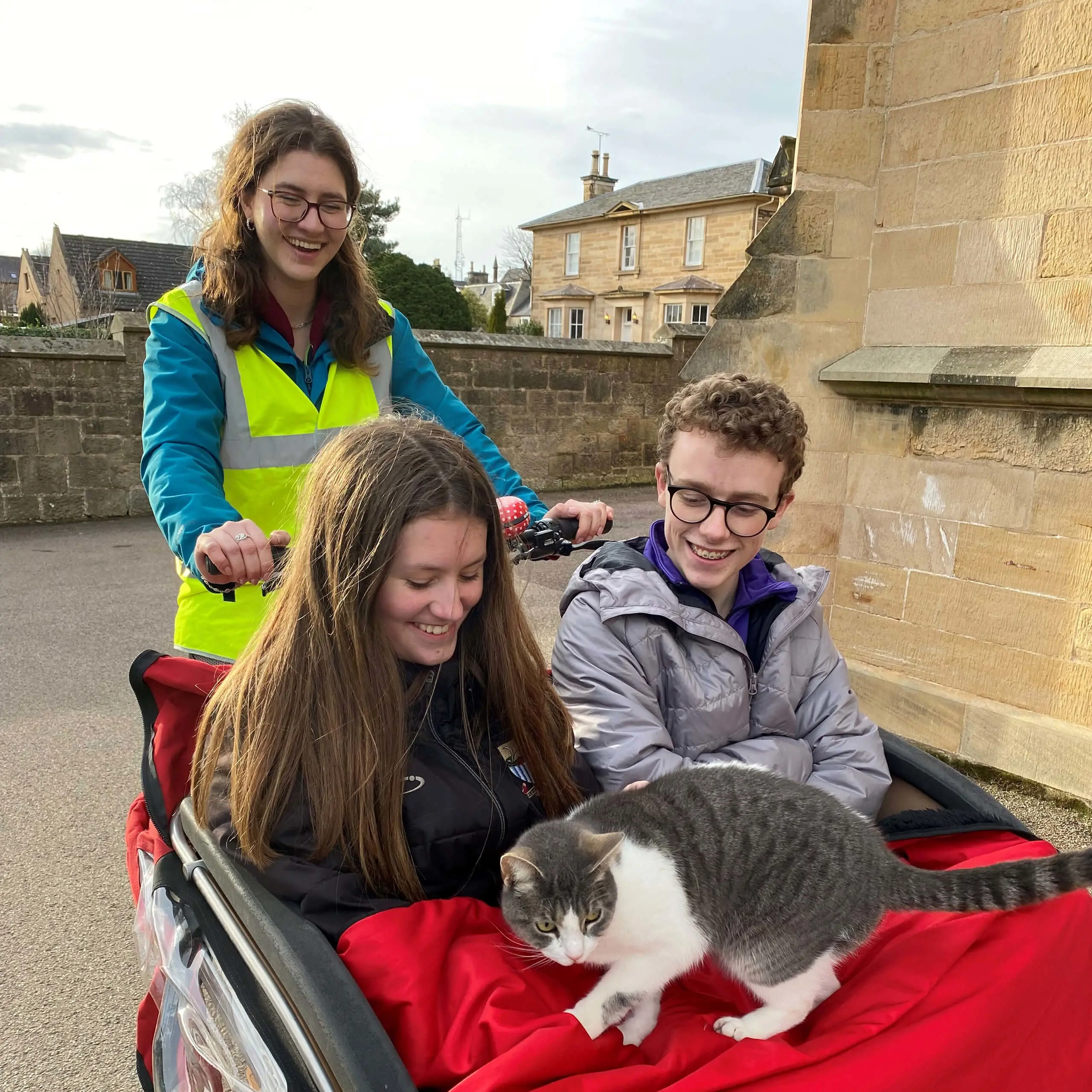 Student member of Gordonstoun's Community Action Service transporting two people and a cat with a cargo bike.