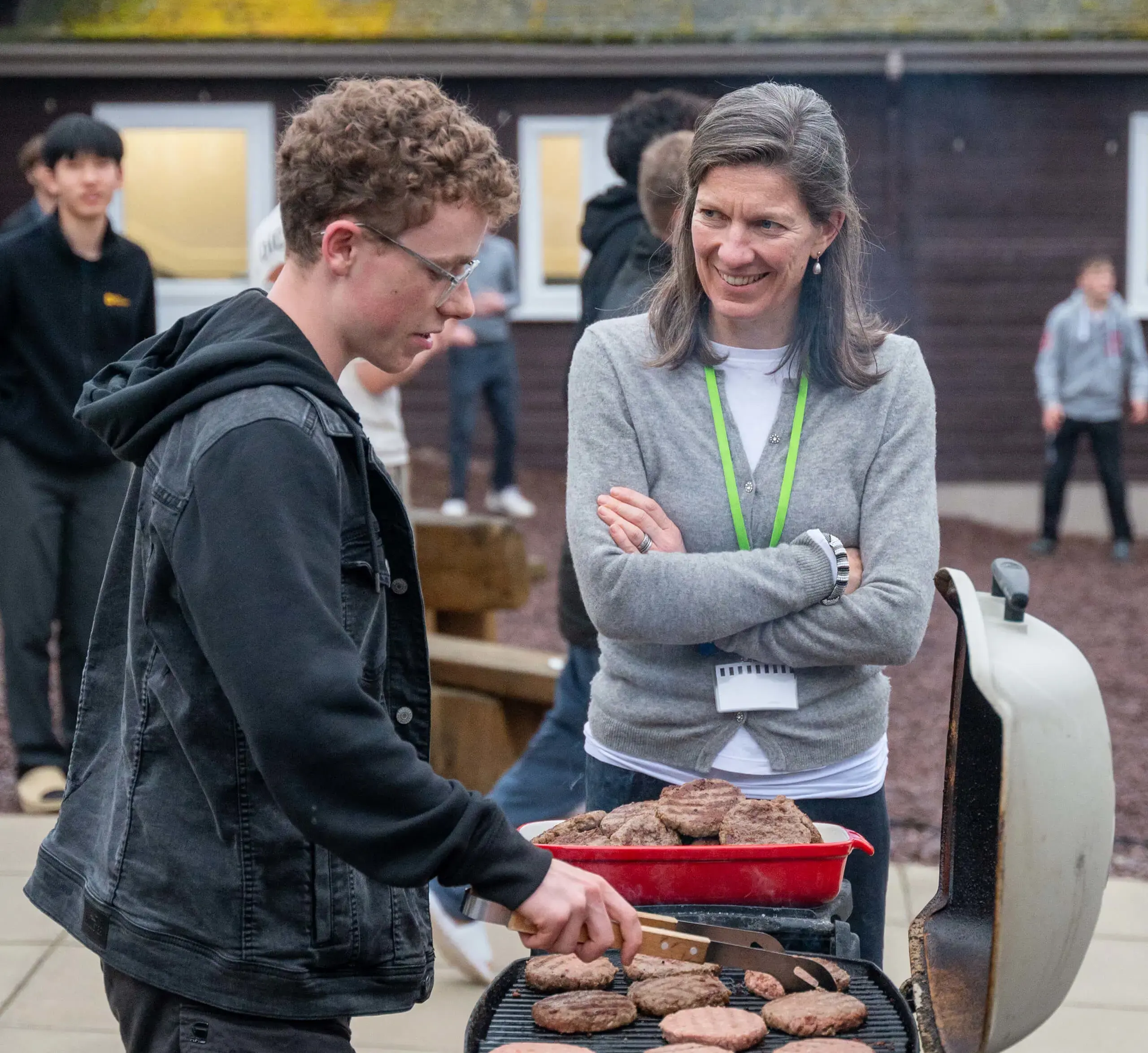 Tutor enjoying a BBQ with students at a boarding house brew