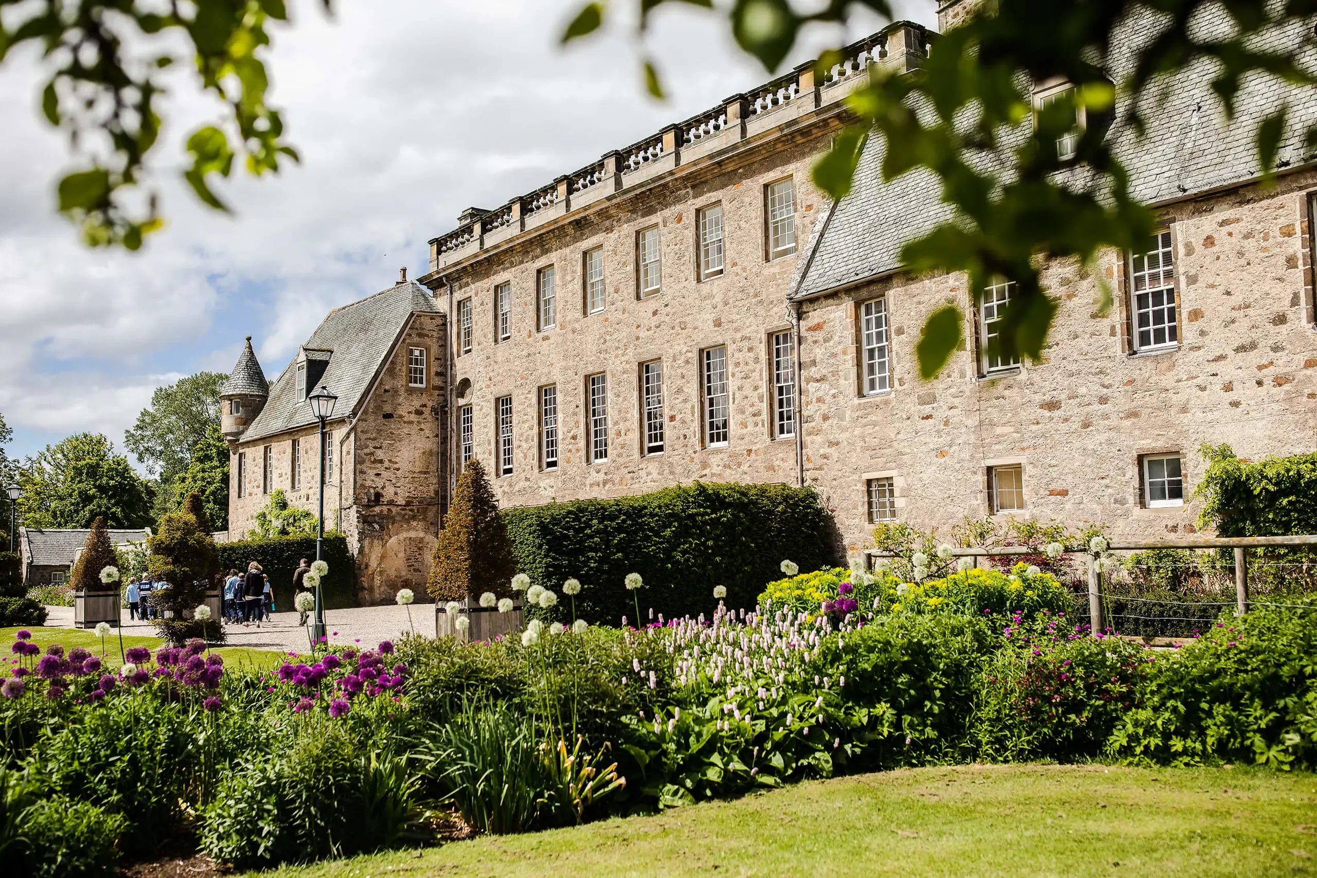 Gordonstoun House in the sunshine through the trees