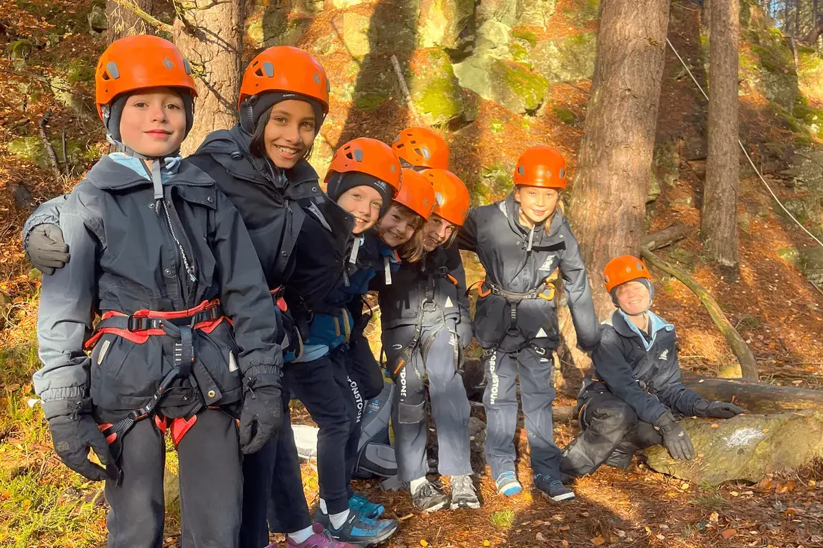 Gordonstoun Prep pupils in a forest with safety helmets on for climbing